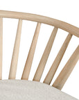 Lightwood spindle dining chair with a curved backrest and white upholstered seat, showcasing a modern yet timeless design. Crafted from solid wood, this chair brings a refined, natural aesthetic to any dining or living space