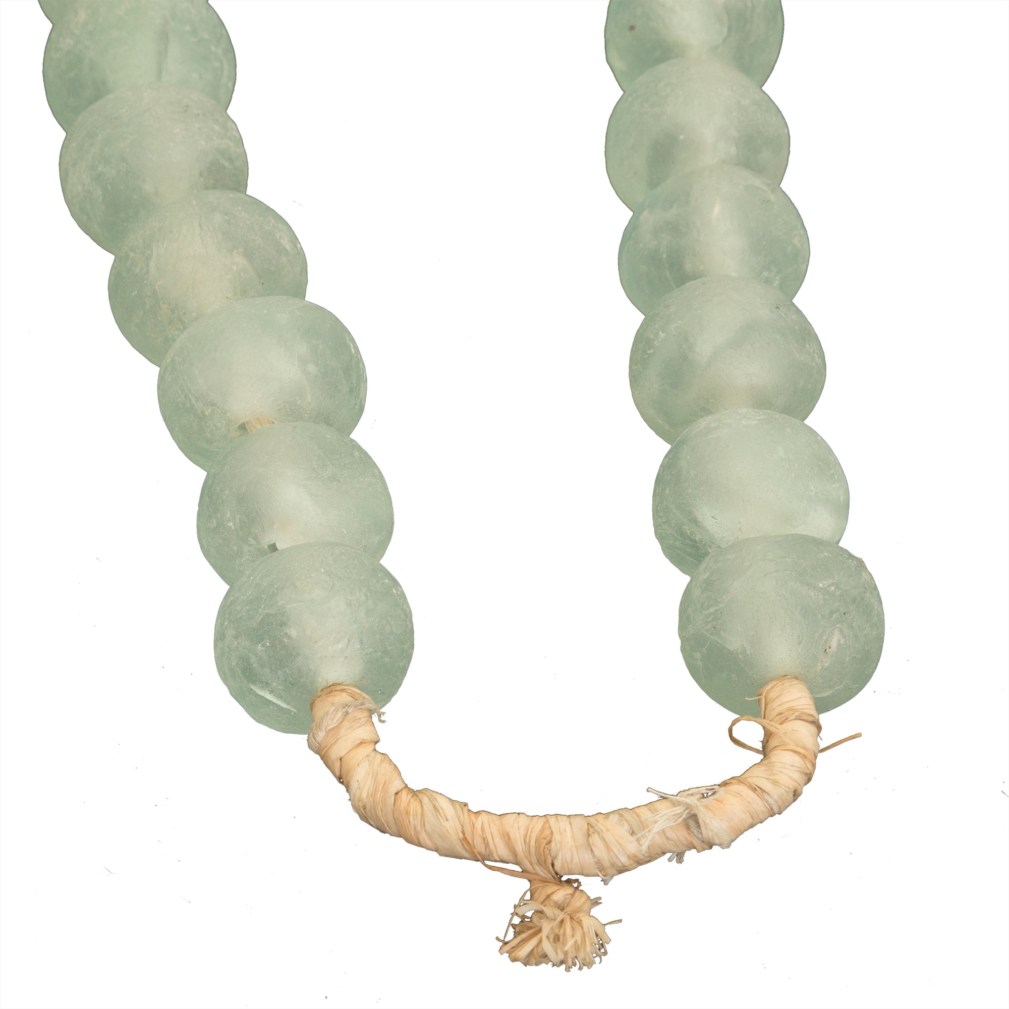 Decorative strand of recycled glass beads in a soft green hue, displayed on a minimalist black metal stand. A unique accent piece that adds texture and artisanal charm to any interior styling