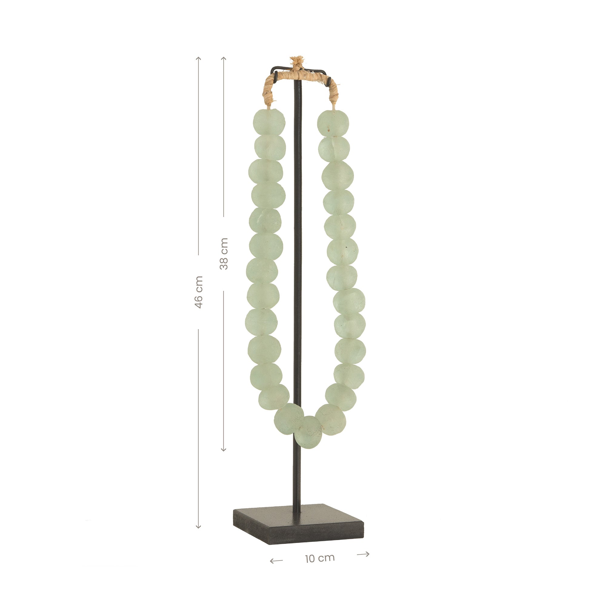 Decorative strand of recycled glass beads in a soft green hue, displayed on a minimalist black metal stand. A unique accent piece that adds texture and artisanal charm to any interior styling