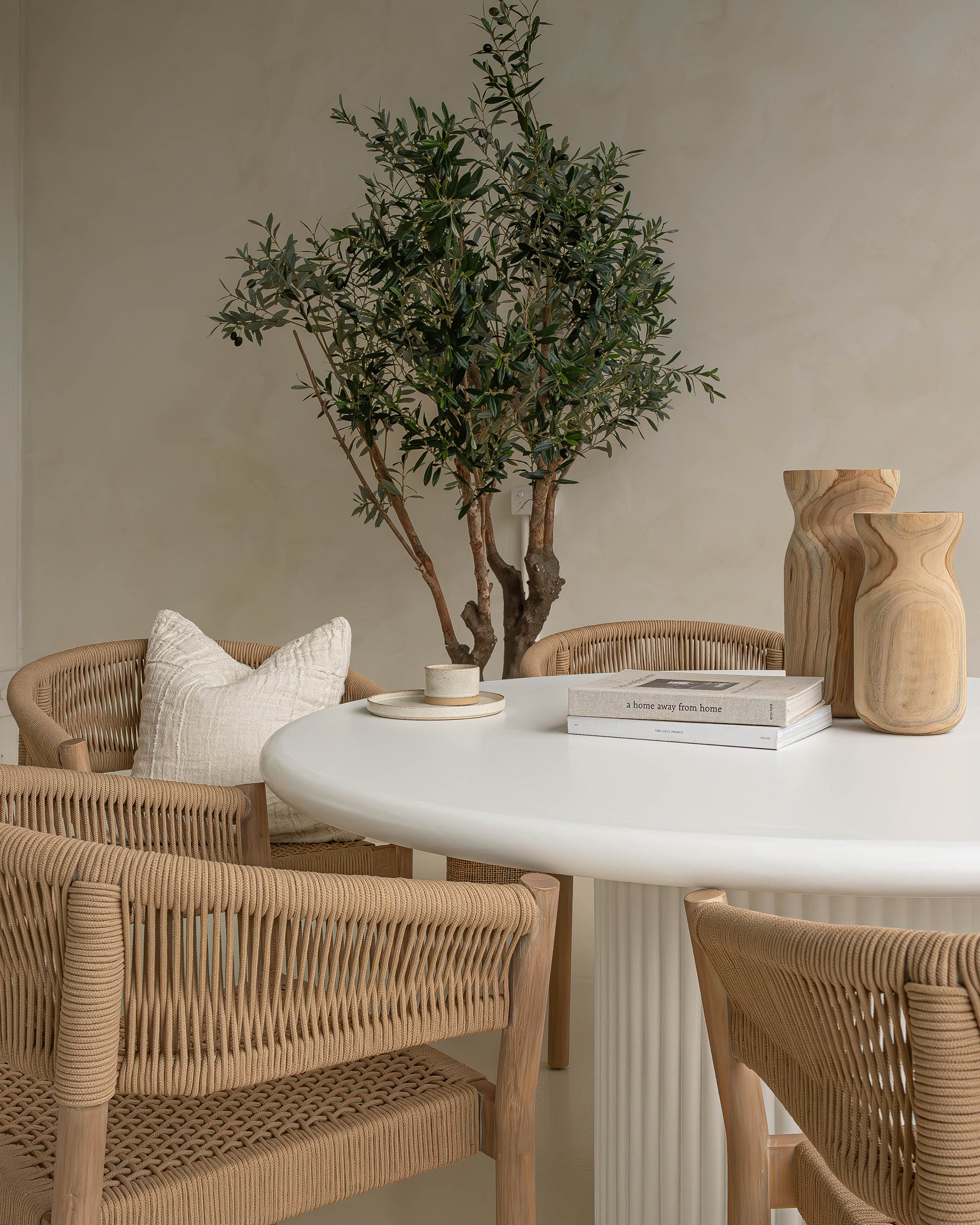 Modern white round dining table featuring a smooth tabletop and a fluted pedestal base. A contemporary statement piece designed to bring elegance and sophistication to any dining space