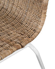 Contemporary dining chair with a sleek white metal frame and a handwoven natural rattan seat and backrest, offering a stylish and comfortable alfresco seating option