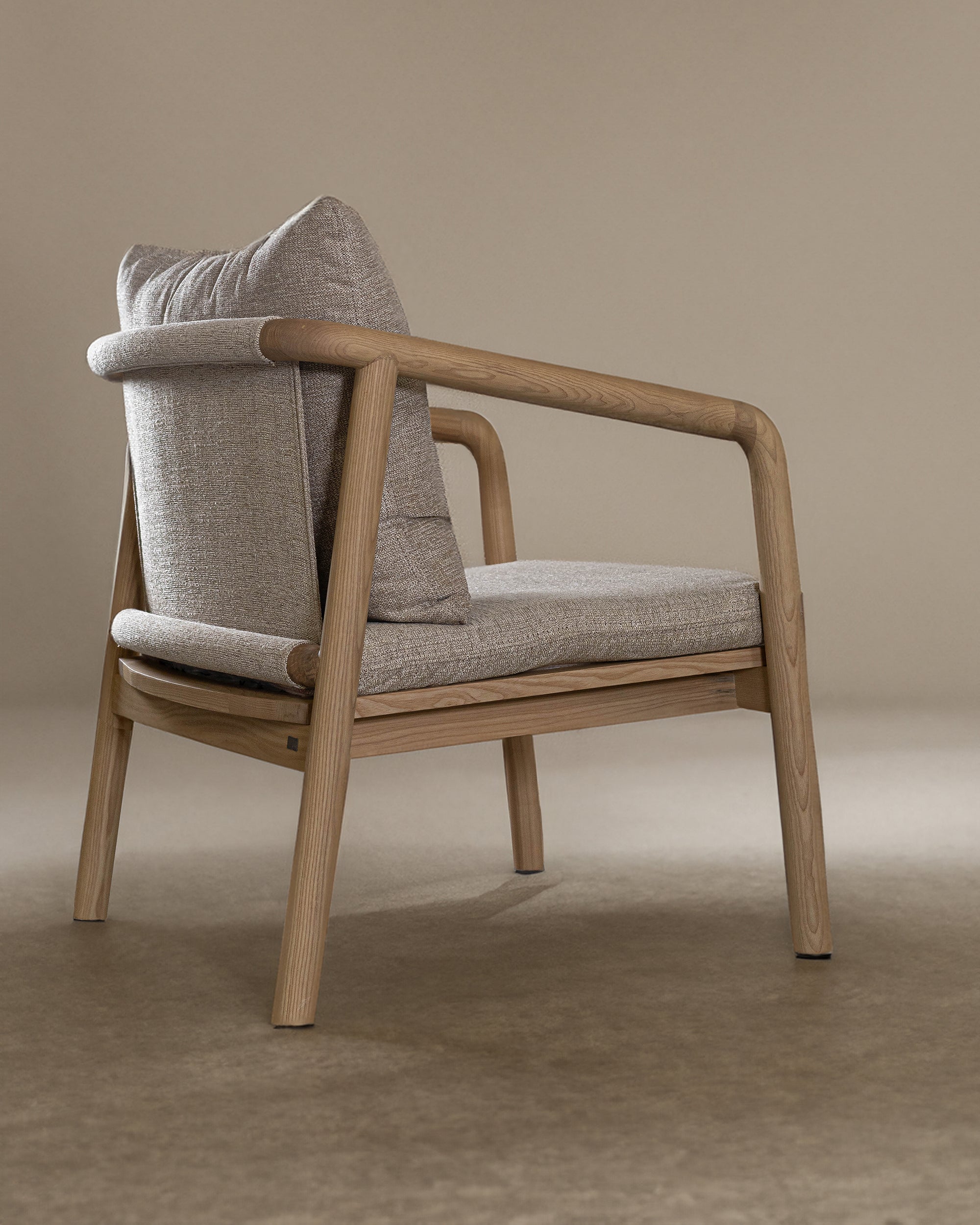 Minimalist ash armchair with natural linen cushions, featuring a sleek Scandinavian-inspired frame