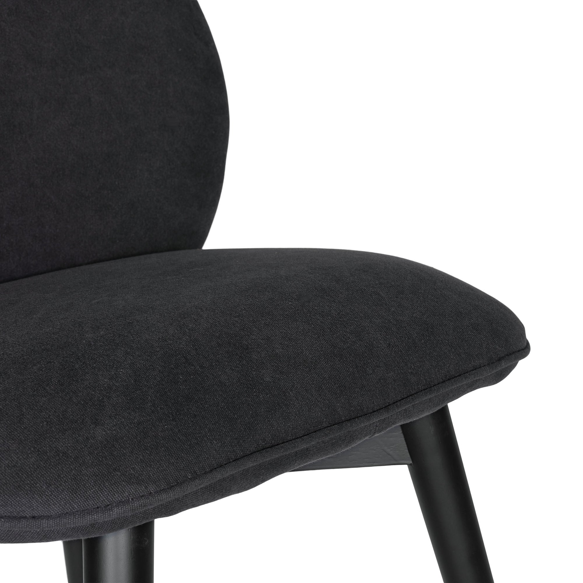 Side profile of a modern black dining chair with sleek black timber legs, offering a sophisticated and contemporary seating option