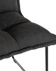 Black cushioned dining chair with a plush padded seat and high backrest, supported by a sleek black metal frame for a contemporary and comfortable seating option