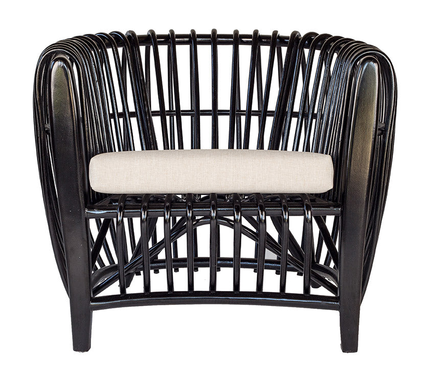 Bold black rattan lounge chair featuring an intricate open-weave frame and a neutral seat cushion for modern coastal elegance