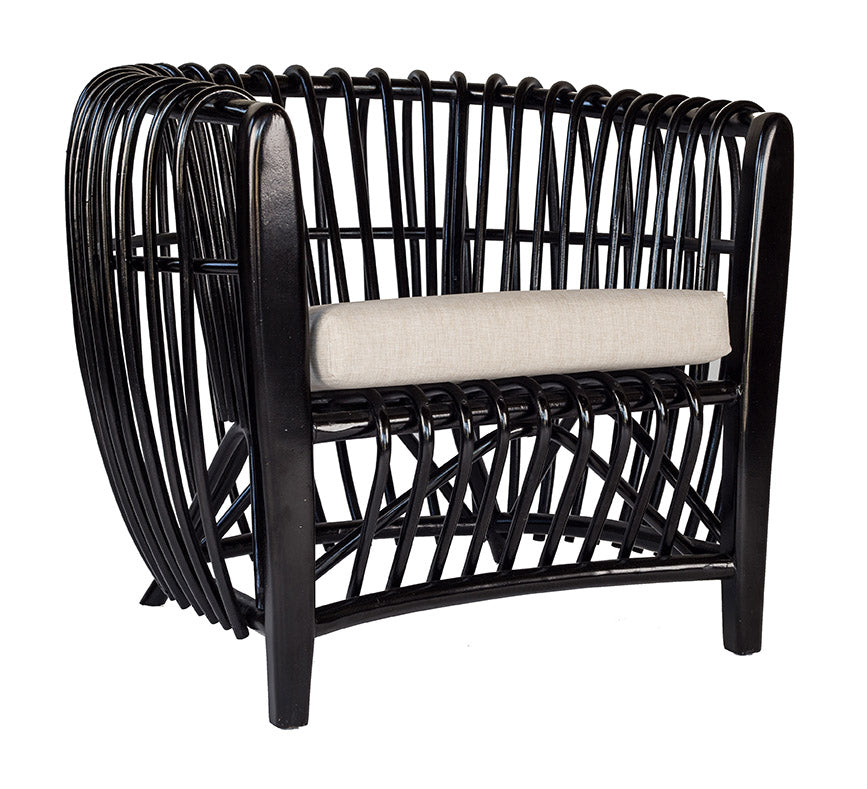 Bold black rattan lounge chair featuring an intricate open-weave frame and a neutral seat cushion for modern coastal elegance