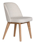 Elegant boucle dining chair with a curved upholstered backrest and plush cushioned seat, supported by tapered lightwood legs. A refined and comfortable seating option for modern dining spaces