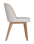 Elegant boucle dining chair with a curved upholstered backrest and plush cushioned seat, supported by tapered lightwood legs. A refined and comfortable seating option for modern dining spaces