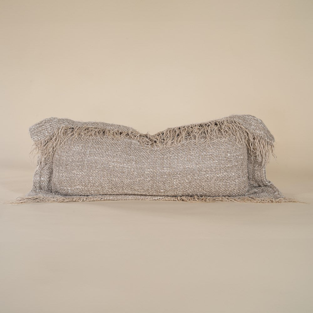 A natural-toned fringed lumbar cushion with a textured woven finish, adding warmth and organic style to any space. Perfect for layering on a bed or sofa