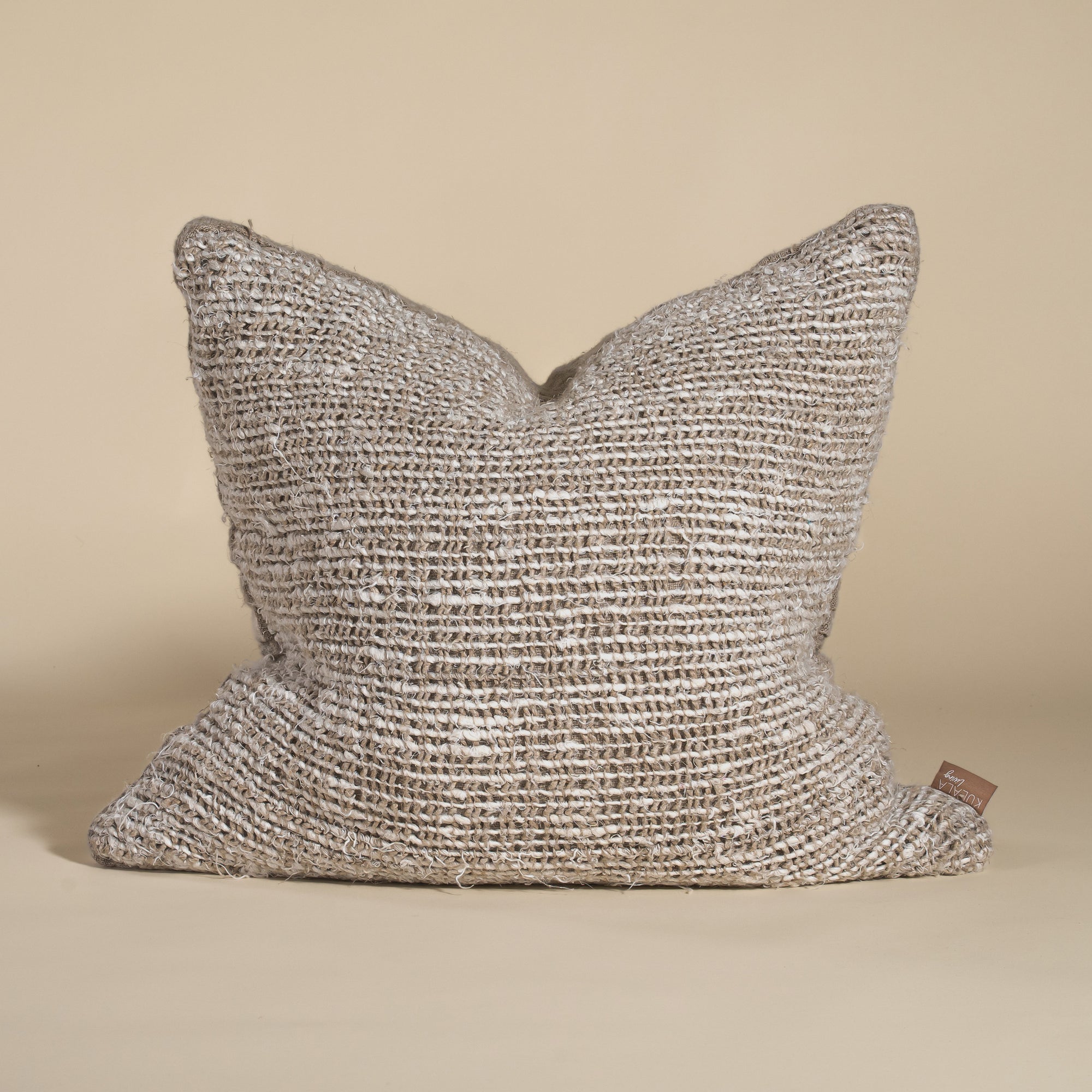 Handwoven cushion cover in earthy tones with a rich, organic texture, perfect for adding warmth to any space