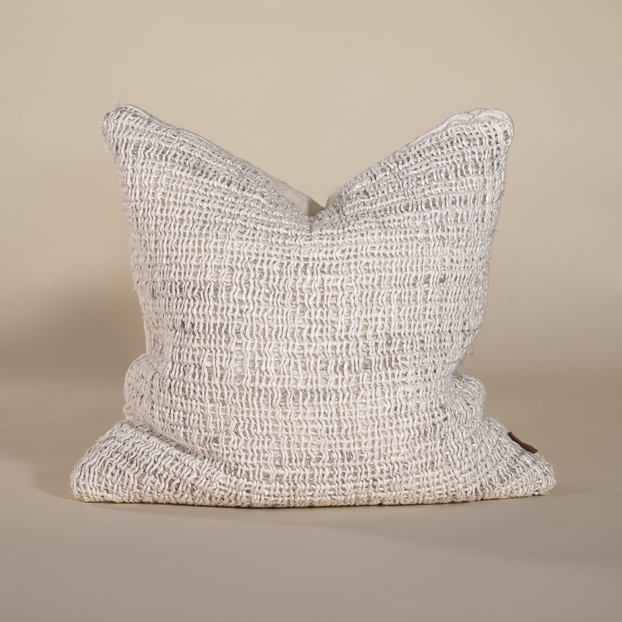 Handwoven neutral-toned cushion cover with rich texture, adding warmth and an organic touch to any space