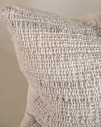 Detailed close-up of an off-white handwoven cushion, highlighting its intricate texture and natural woven fibres