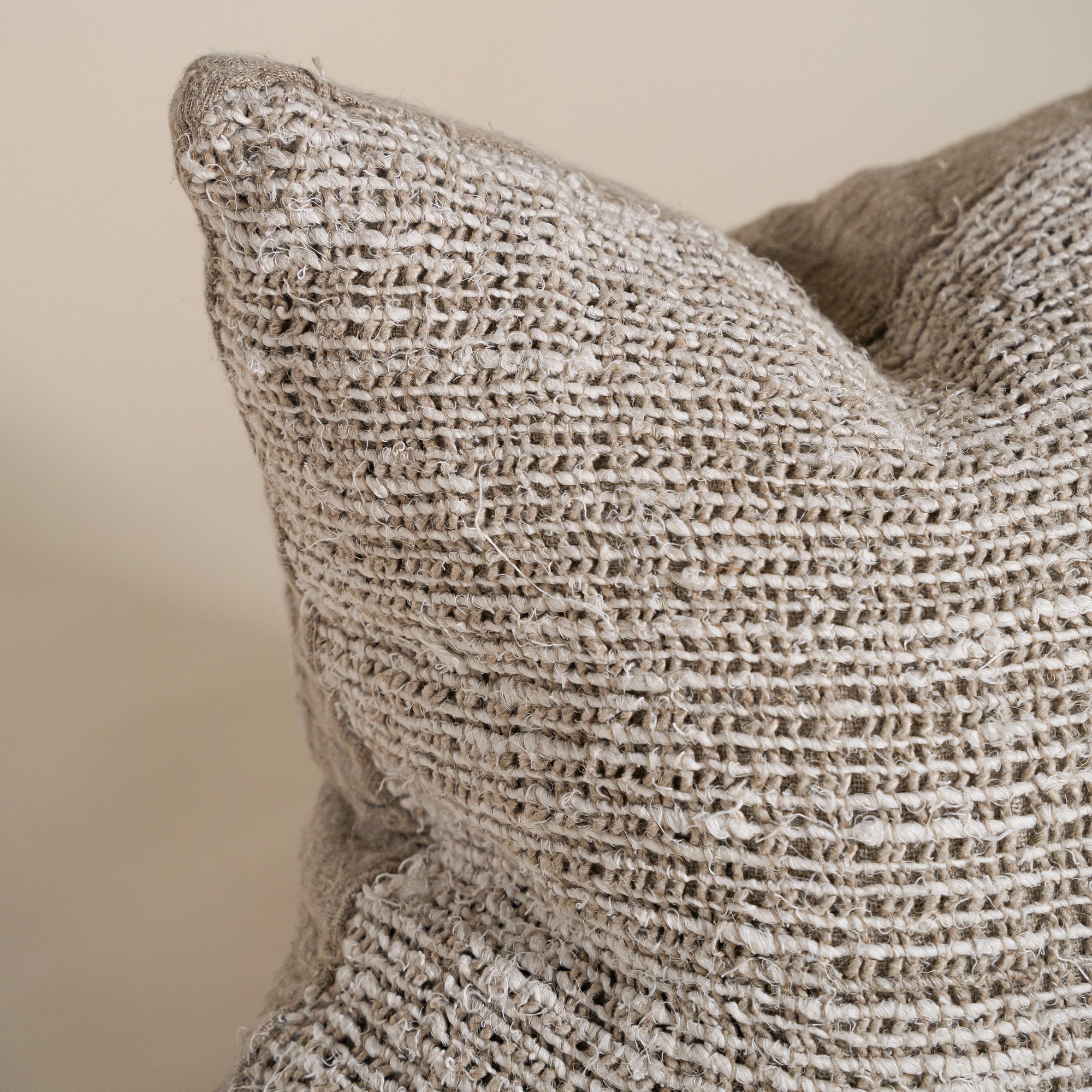 Close-up of a handwoven cushion in natural fibres, showcasing its rich texture and artisanal craftsmanship