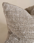 Close-up of a handwoven cushion in natural fibres, showcasing its rich texture and artisanal craftsmanship