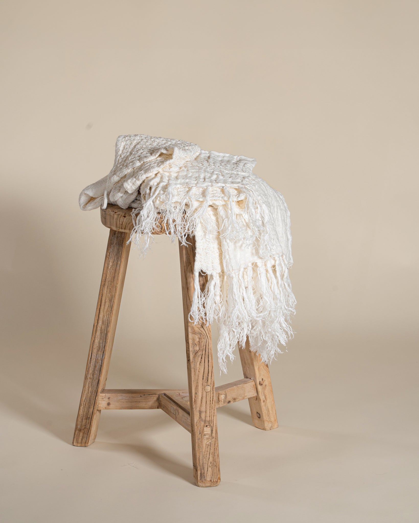 A soft, handwoven cream towel and face washer from KULALA Living, featuring delicate fringe detailing. Perfect for adding warmth and texture to any space