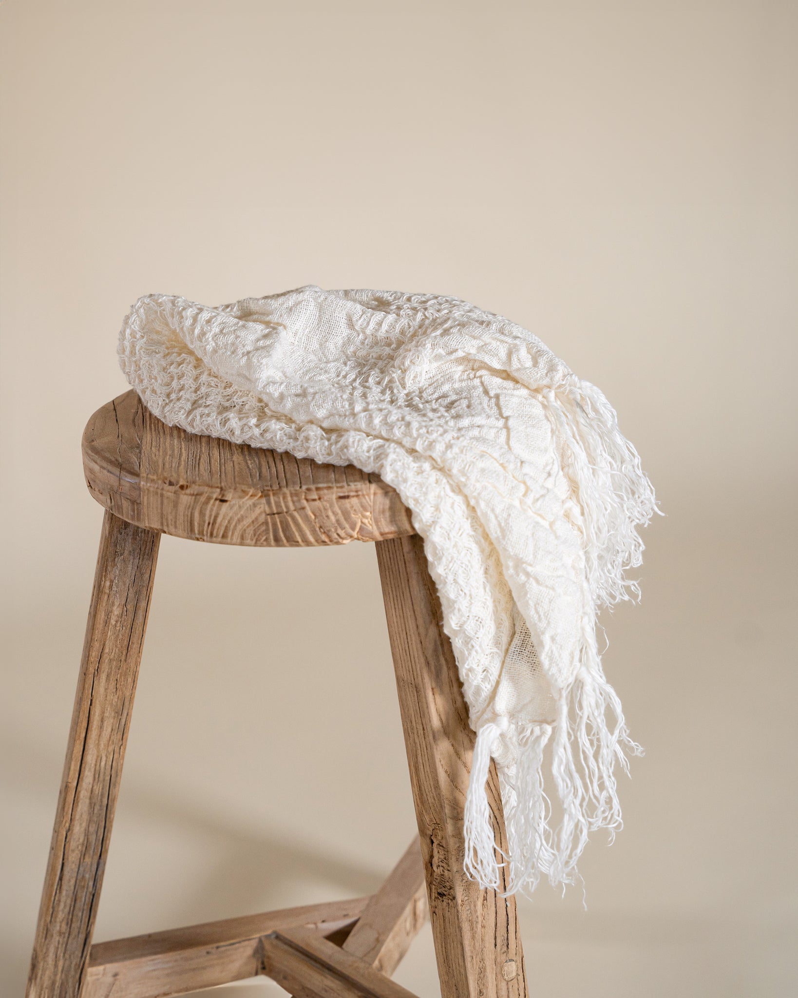 A soft, handwoven cream towel and face washer from KULALA Living, featuring delicate fringe detailing. Perfect for adding warmth and texture to any space