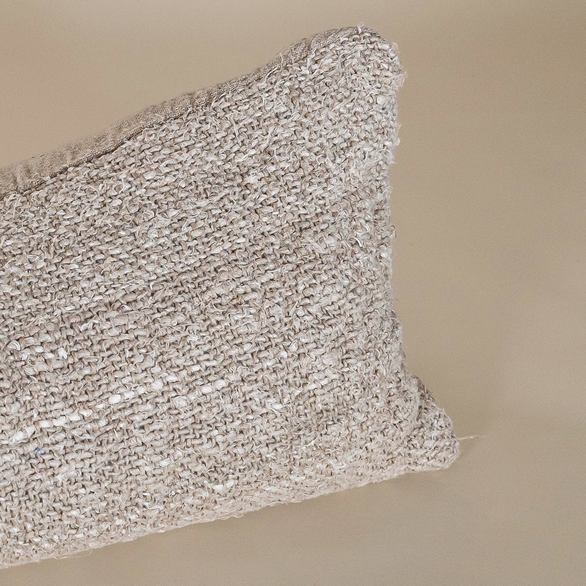 A handwoven lumbar cushion in a natural tone, offering an organic texture and artisanal charm. Perfect for layering on a bed or sofa, this cushion enhances a neutral, earthy interior aesthetic