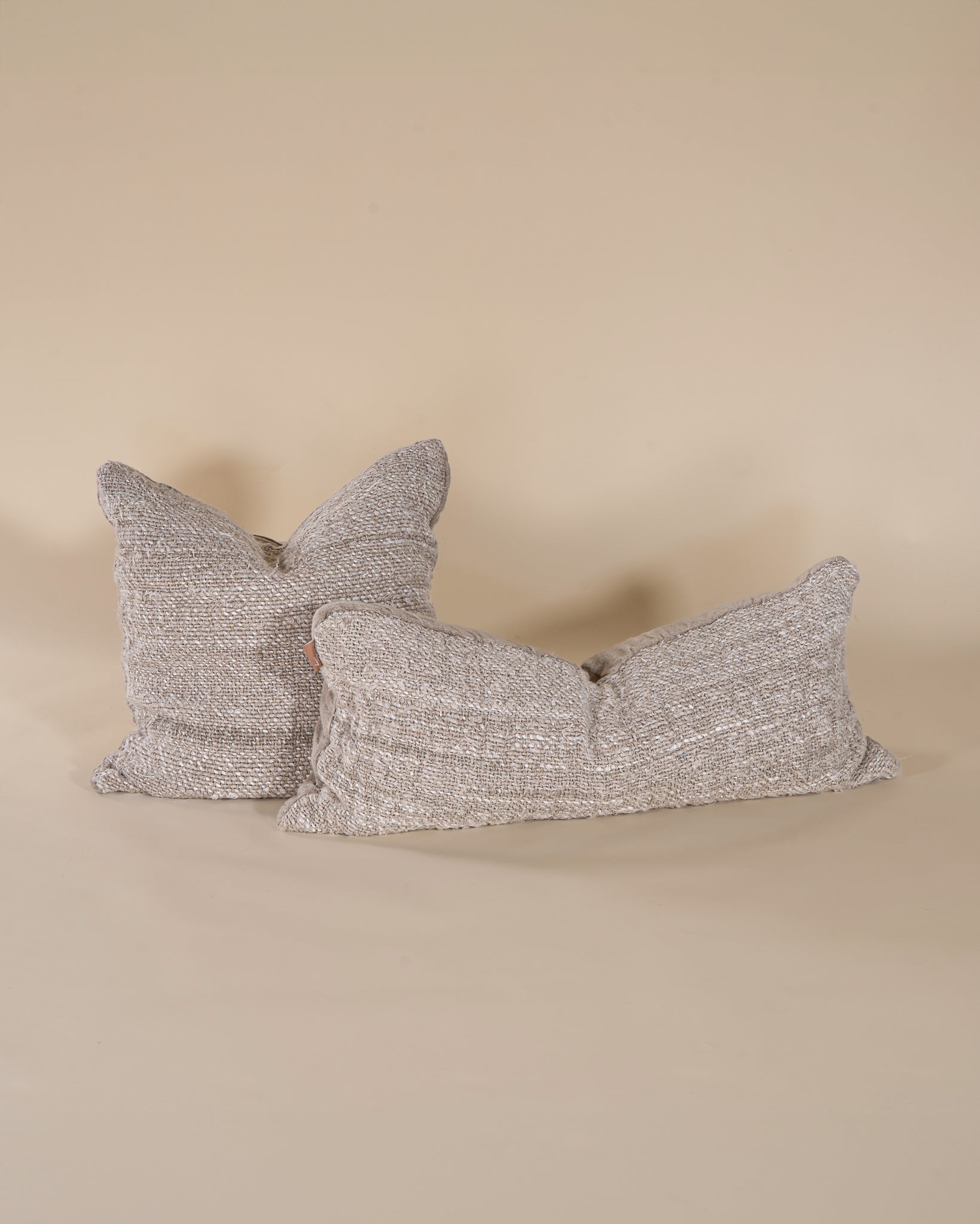 A handwoven lumbar cushion in a natural tone, offering an organic texture and artisanal charm. Perfect for layering on a bed or sofa, this cushion enhances a neutral, earthy interior aesthetic