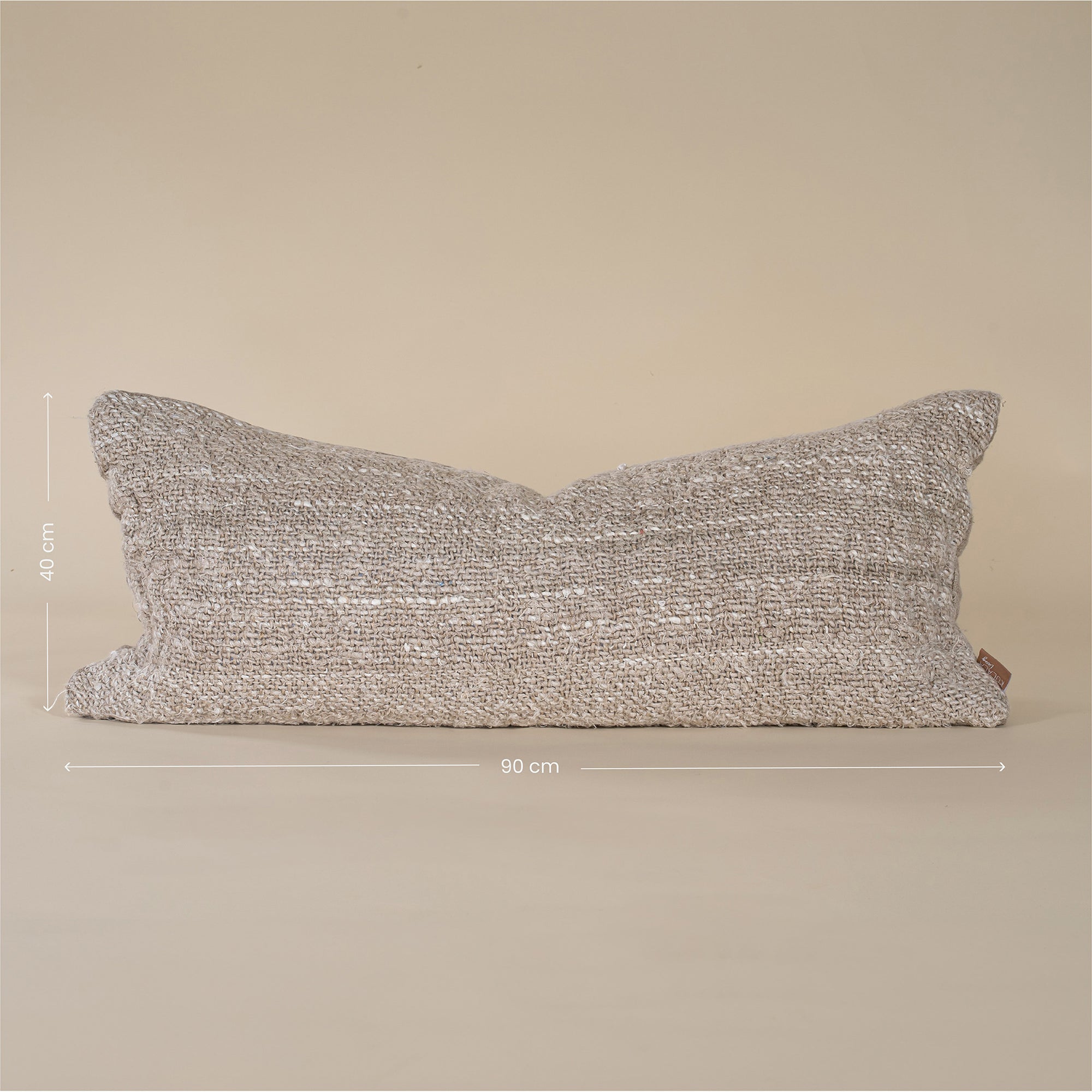 A handwoven lumbar cushion in a natural tone, offering an organic texture and artisanal charm. Perfect for layering on a bed or sofa, this cushion enhances a neutral, earthy interior aesthetic