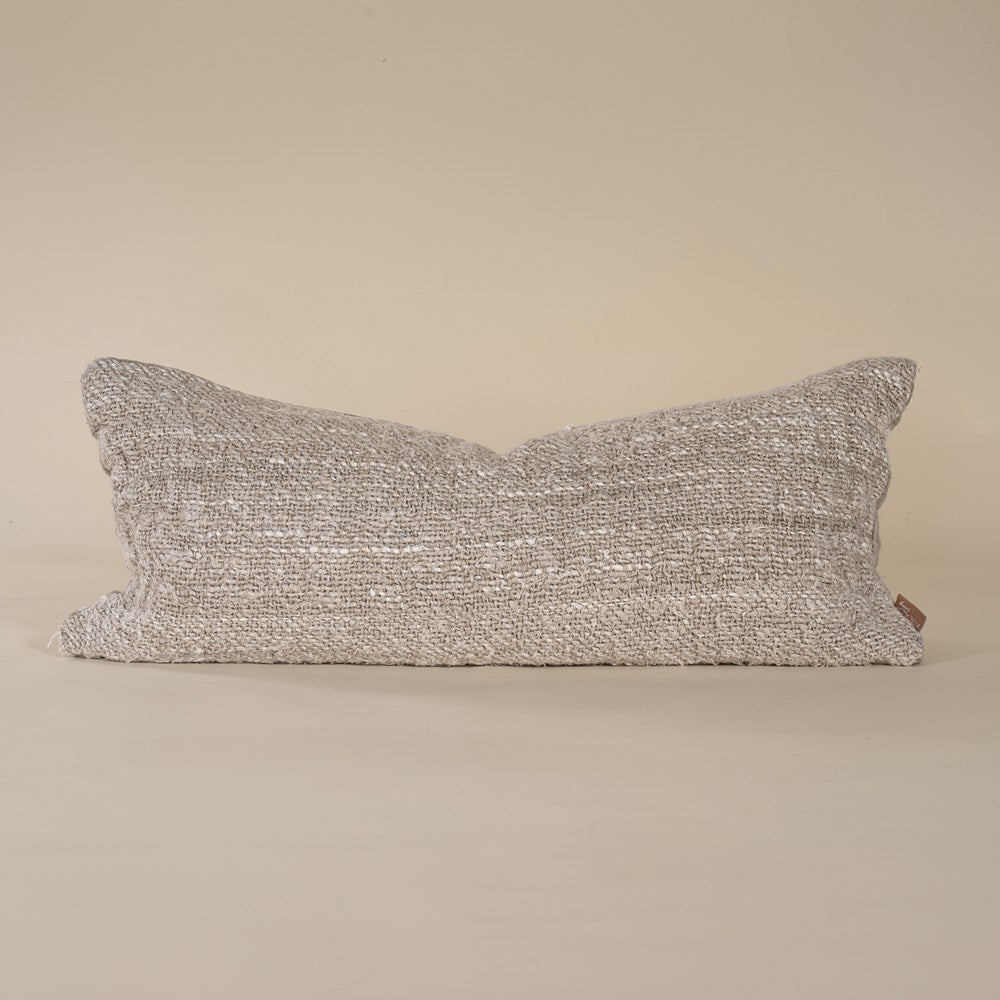 A handwoven lumbar cushion in a natural tone, offering an organic texture and artisanal charm. Perfect for layering on a bed or sofa, this cushion enhances a neutral, earthy interior aesthetic