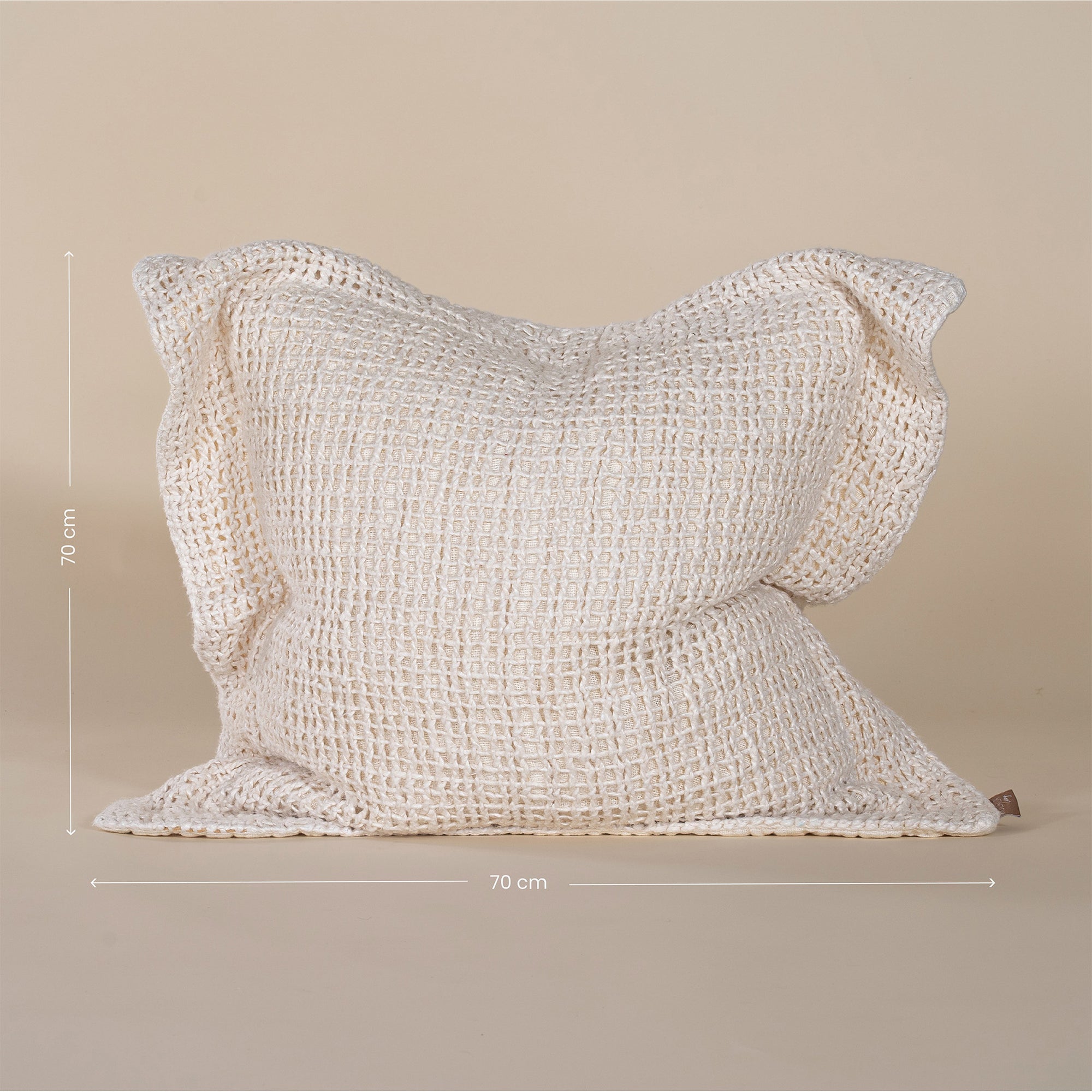 A handcrafted ivory cushion with an open-weave texture, made from natural fibres, adding warmth and artisanal charm to any living space.