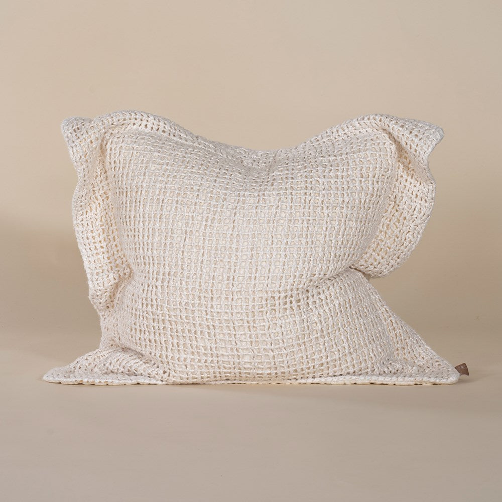 A handcrafted ivory cushion with an open-weave texture, made from natural fibres, adding warmth and artisanal charm to any living space.