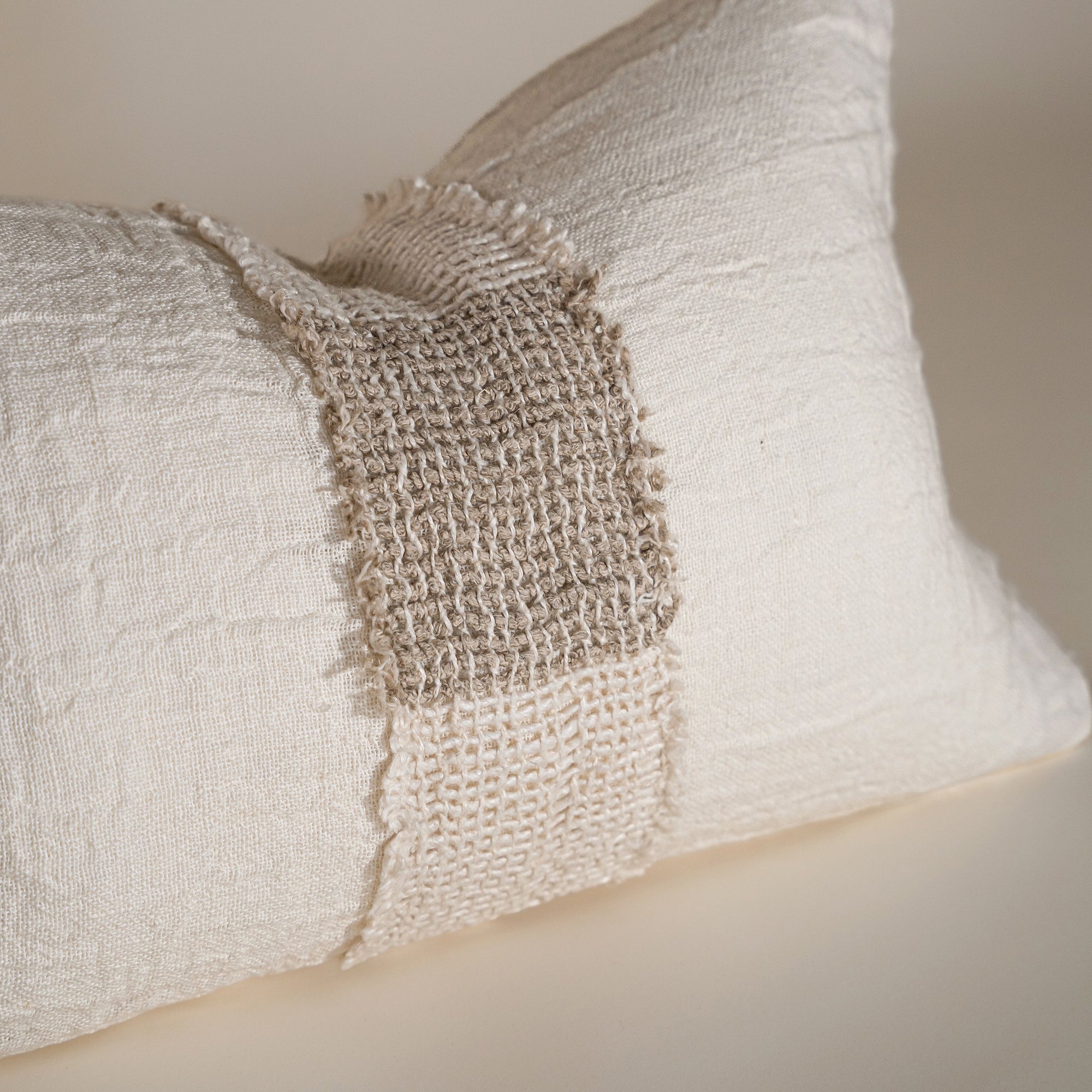 Handcrafted linen cushion in a soft cream hue, featuring a textured woven centre panel for a rustic yet refined aesthetic