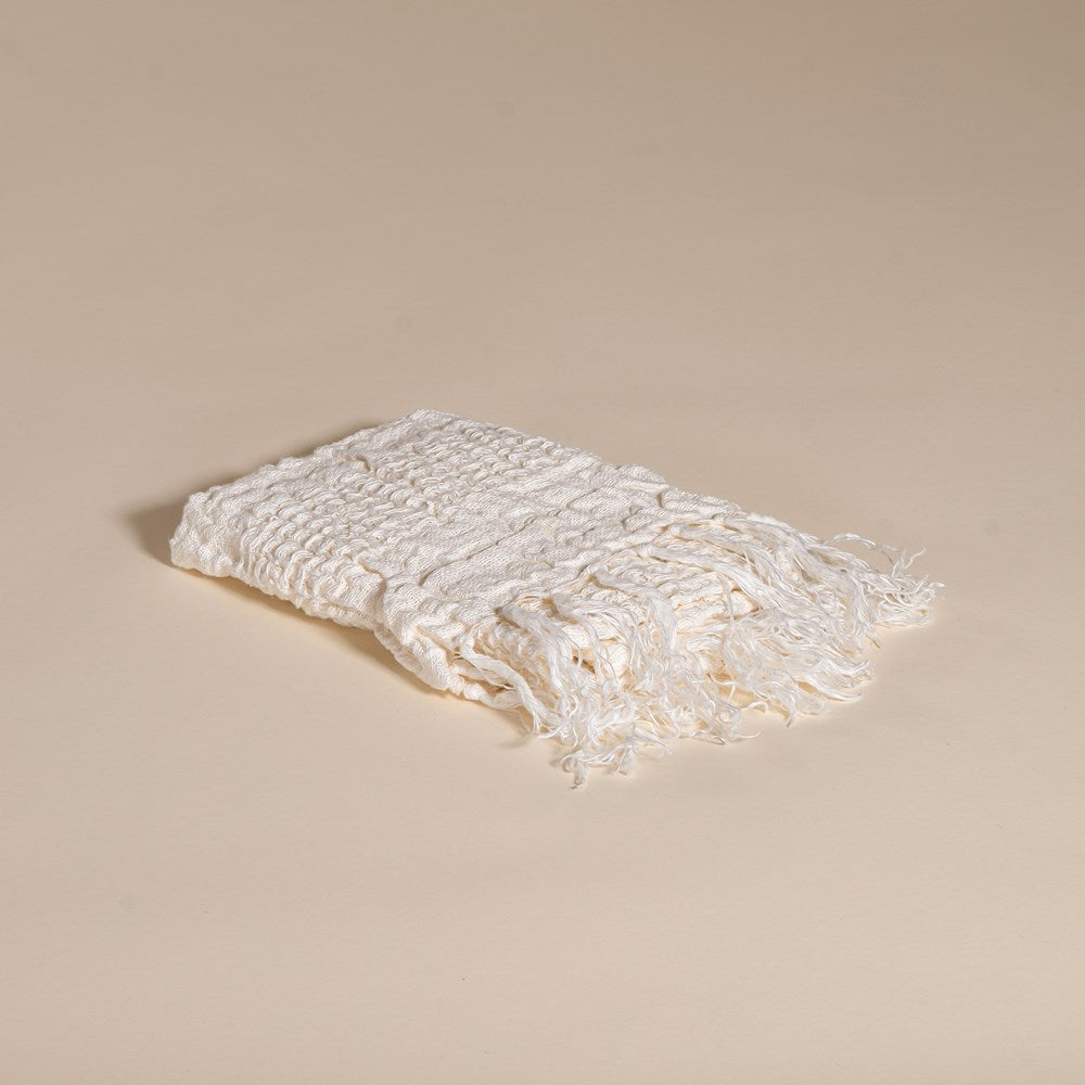 An elegant off-white handwoven linen towel from KULALA Living, featuring a soft texture and delicate fringed edges. A perfect layering piece for a relaxed, stylish home