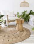 Tranquil lounge space featuring a handcrafted teak side table, woven jute rug, and natural-toned furniture, creating a relaxed and organic atmosphere