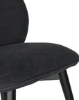 Contemporary black lounge chair with a curved backrest and plush cushioning, supported by sleek black timber legs.