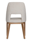 A contemporary dining chair from KULALA Living, featuring soft boucle upholstery and sturdy natural timber legs. Designed for comfort and style, perfect for modern dining spaces