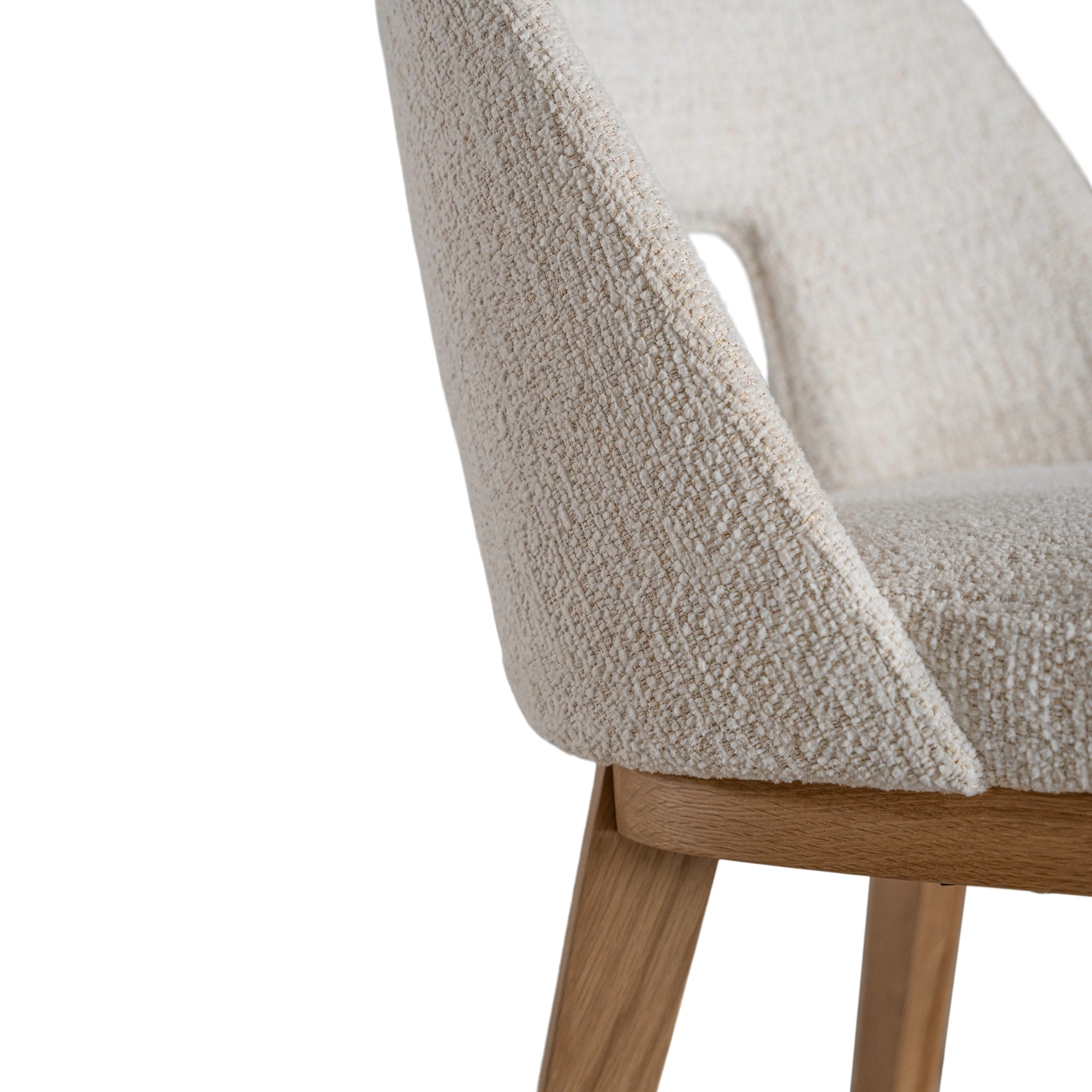 A contemporary dining chair from KULALA Living, featuring soft boucle upholstery and sturdy natural timber legs. Designed for comfort and style, perfect for modern dining spaces