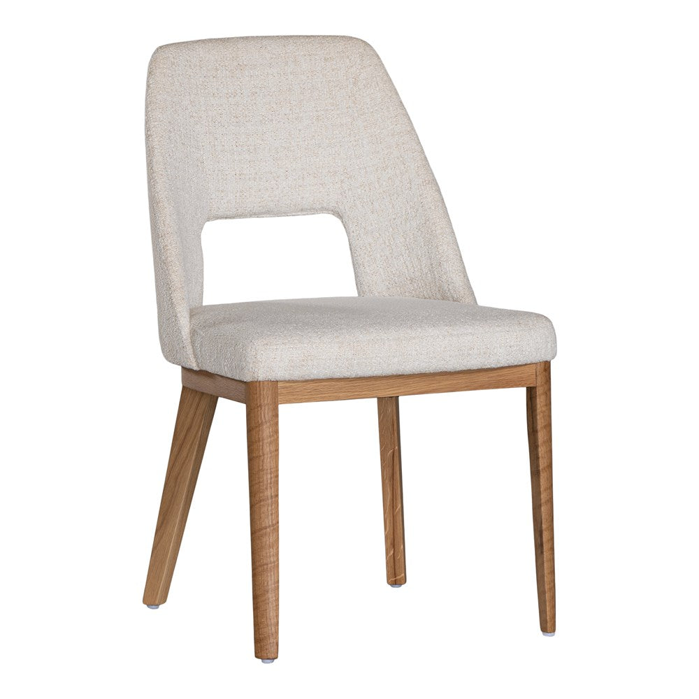 A contemporary dining chair from KULALA Living, featuring soft boucle upholstery and sturdy natural timber legs. Designed for comfort and style, perfect for modern dining spaces