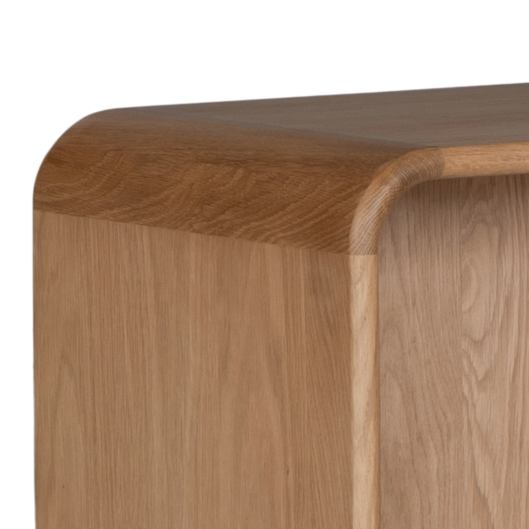 A modern oak bedside table from KULALA Living, featuring a curved silhouette and open storage shelf. Crafted from natural wood, this minimalist piece enhances any bedroom with its warm, organic aesthetic