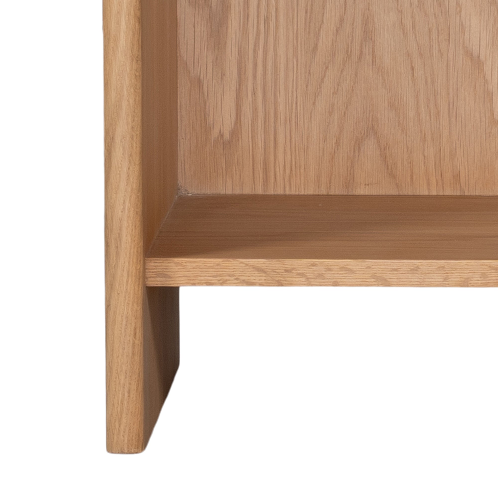 A modern oak bedside table from KULALA Living, featuring a curved silhouette and open storage shelf. Crafted from natural wood, this minimalist piece enhances any bedroom with its warm, organic aesthetic