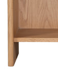 A modern oak bedside table from KULALA Living, featuring a curved silhouette and open storage shelf. Crafted from natural wood, this minimalist piece enhances any bedroom with its warm, organic aesthetic