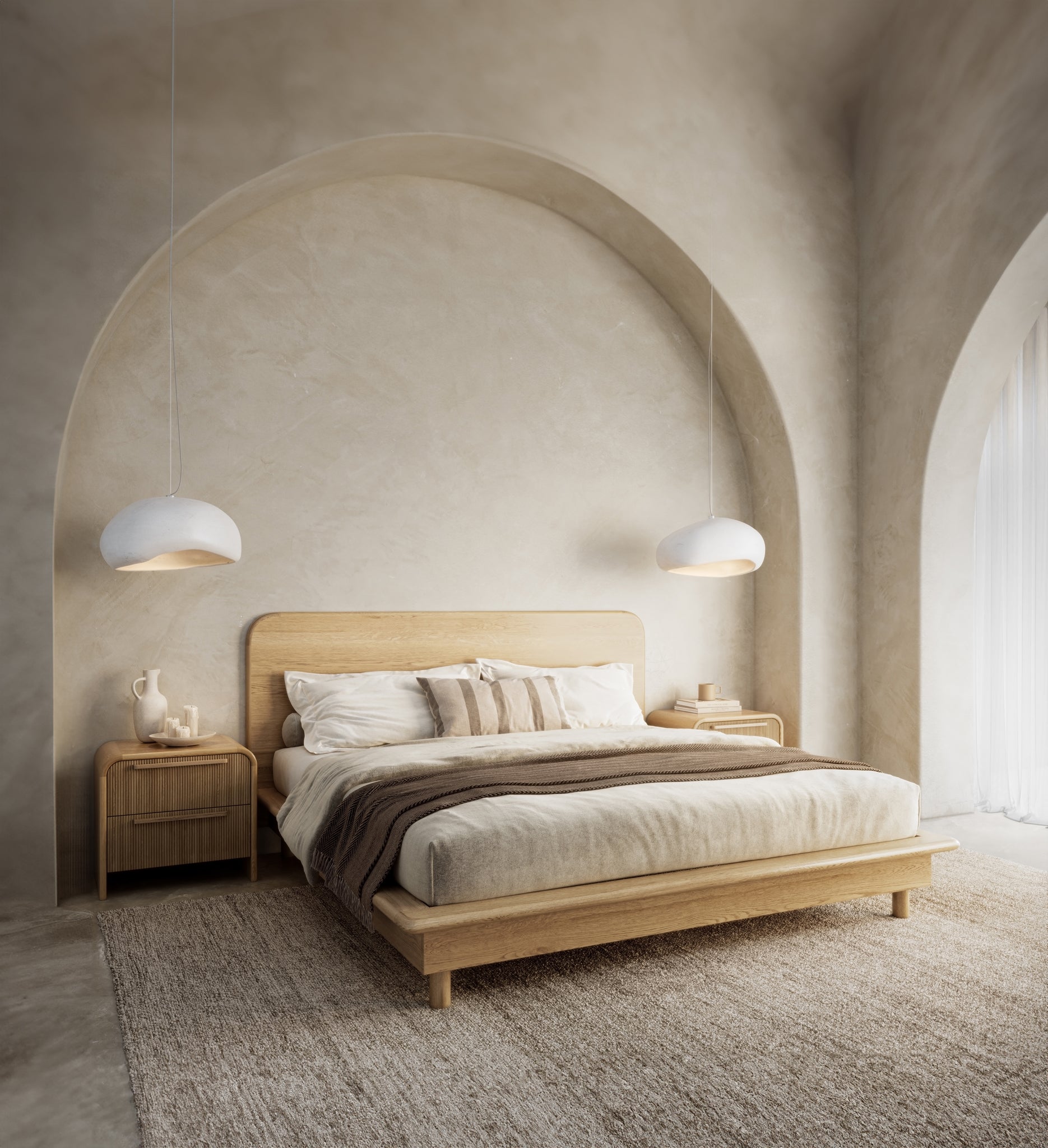 A modern oak platform bed frame from KULALA Living, styled in a serene bedroom setting with arched walls, soft lighting, and natural textures. Complemented by neutral bedding, rattan bedside tables, and pendant lights for a refined, minimalist aesthetic