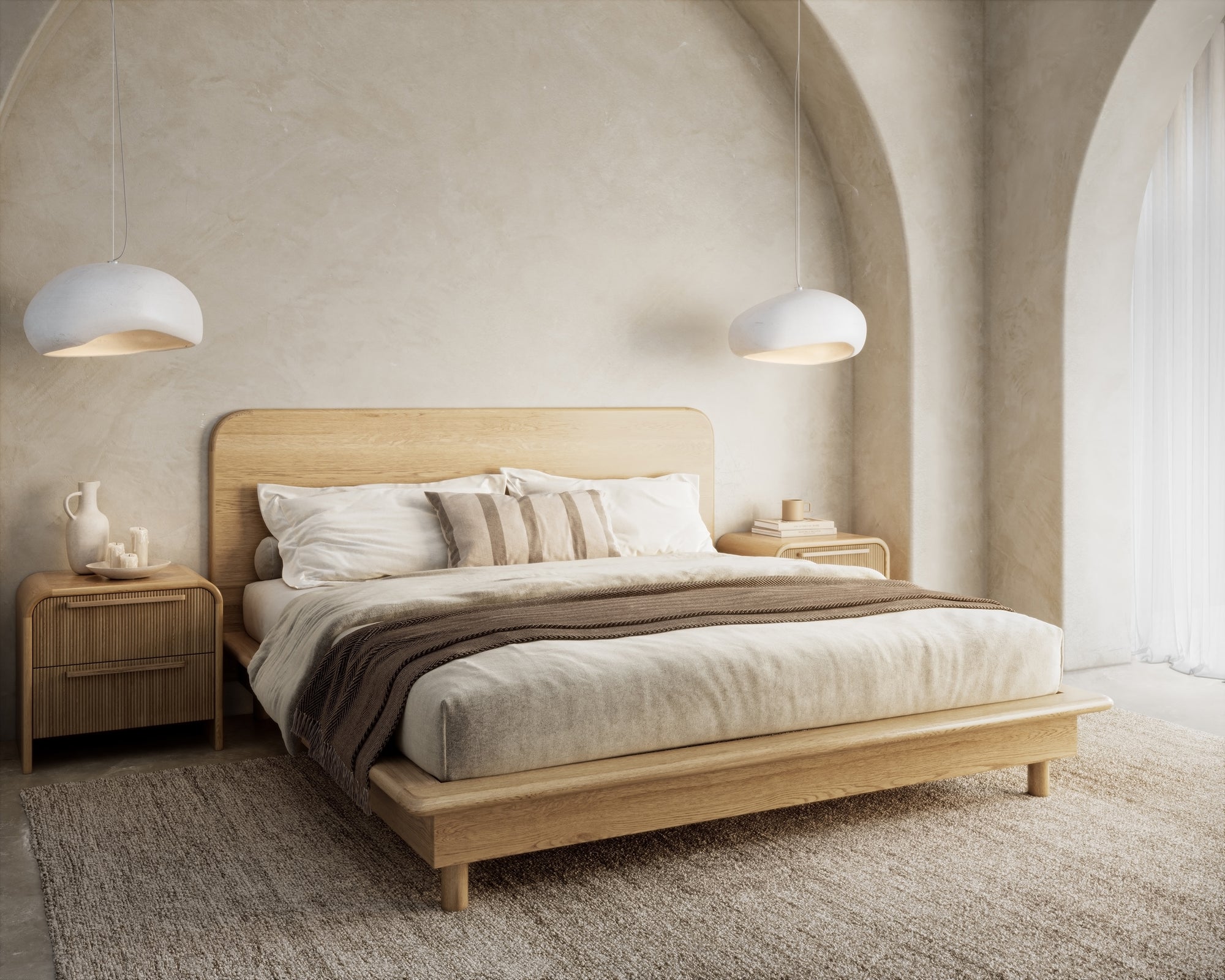 A modern oak platform bed frame from KULALA Living, styled in a serene bedroom setting with arched walls, soft lighting, and natural textures. Complemented by neutral bedding, rattan bedside tables, and pendant lights for a refined, minimalist aesthetic