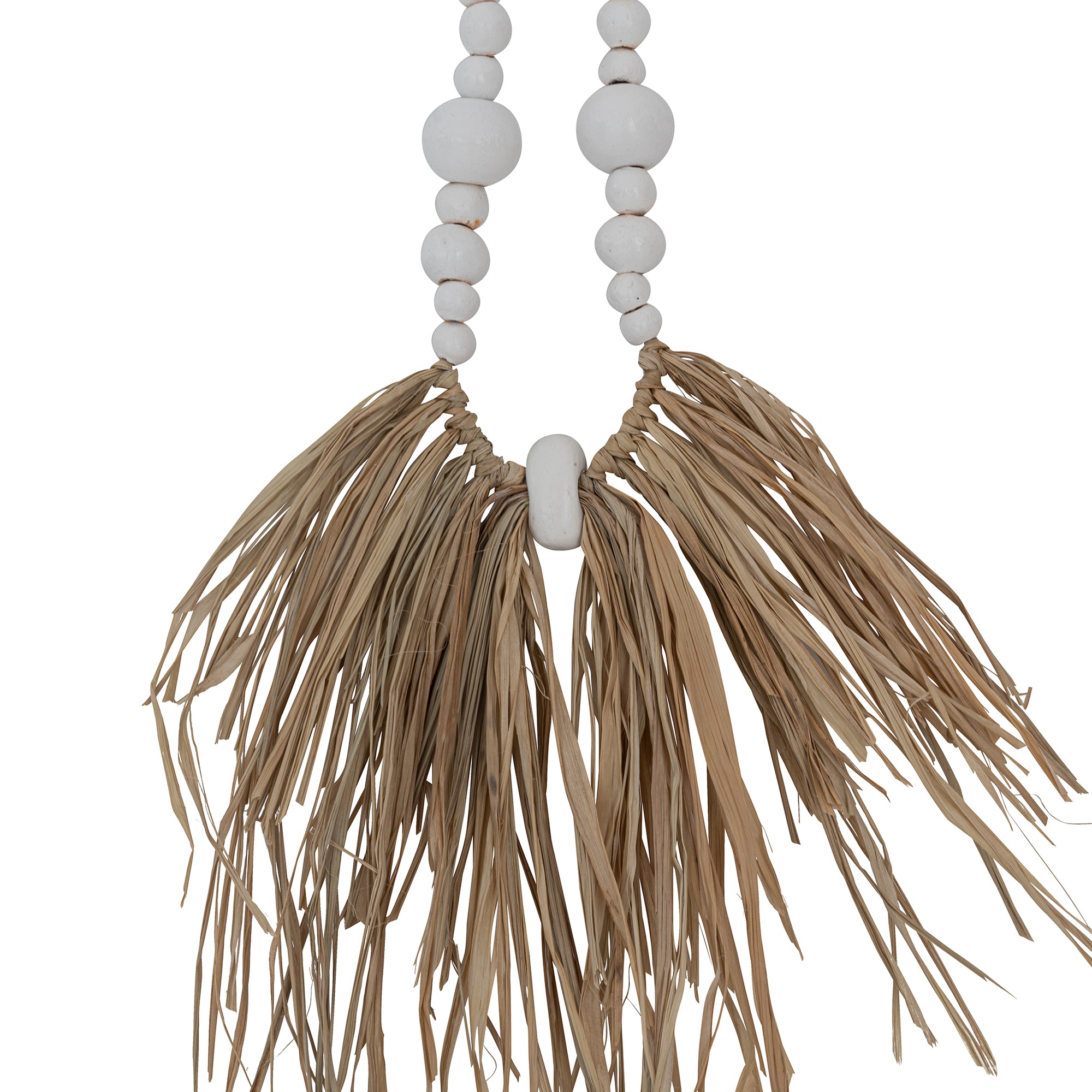 Decorative raffia and shell necklace on a black stand, featuring white wooden beads and natural raffia fringe, ideal for coastal and bohemian interiors