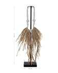 Decorative raffia and shell necklace on a black stand, featuring white wooden beads and natural raffia fringe, ideal for coastal and bohemian interiors