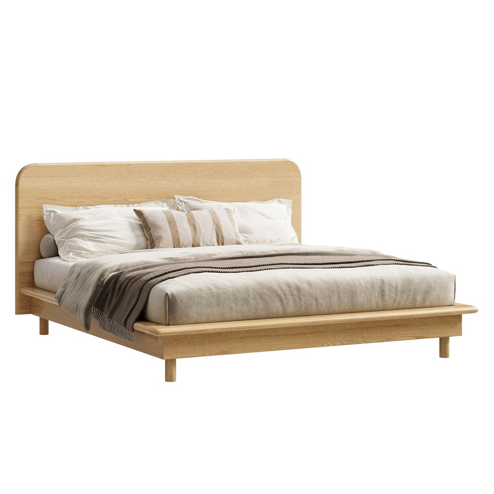 A beautifully crafted oak timber platform bed frame from KULALA Living, featuring a minimalist modern design with a gently curved headboard. Styled with neutral bedding for a serene and inviting bedroom aesthetic