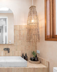 Bathroom featuring a natural rattan pendant light, a stone basin, and neutral-toned tiles, creating a warm and organic aesthetic