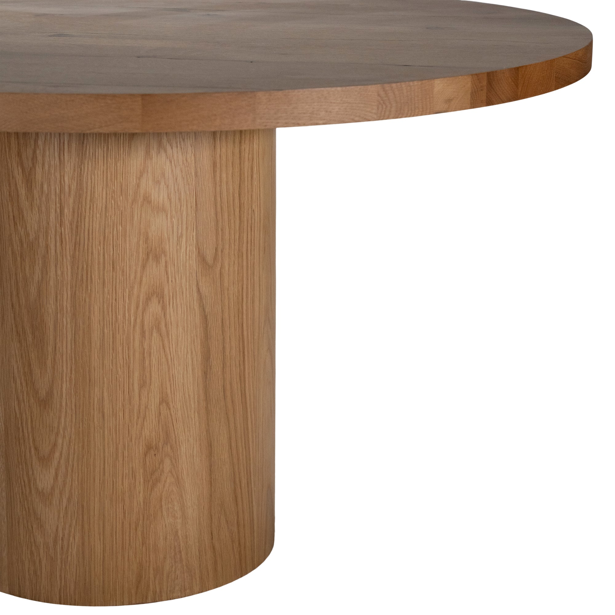 Contemporary round oak pedestal dining table featuring a sleek, minimalist design with a solid cylindrical base and smooth tabletop