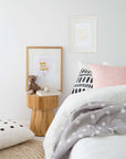 Natural teak side table styled in a cosy bedroom setting, featuring soft textiles, framed artwork, and a plush teddy for a warm and inviting aesthetic