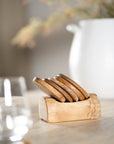 A beautifully crafted teak wood coaster set with a matching holder, adding warmth and natural texture to any dining or coffee table setting.