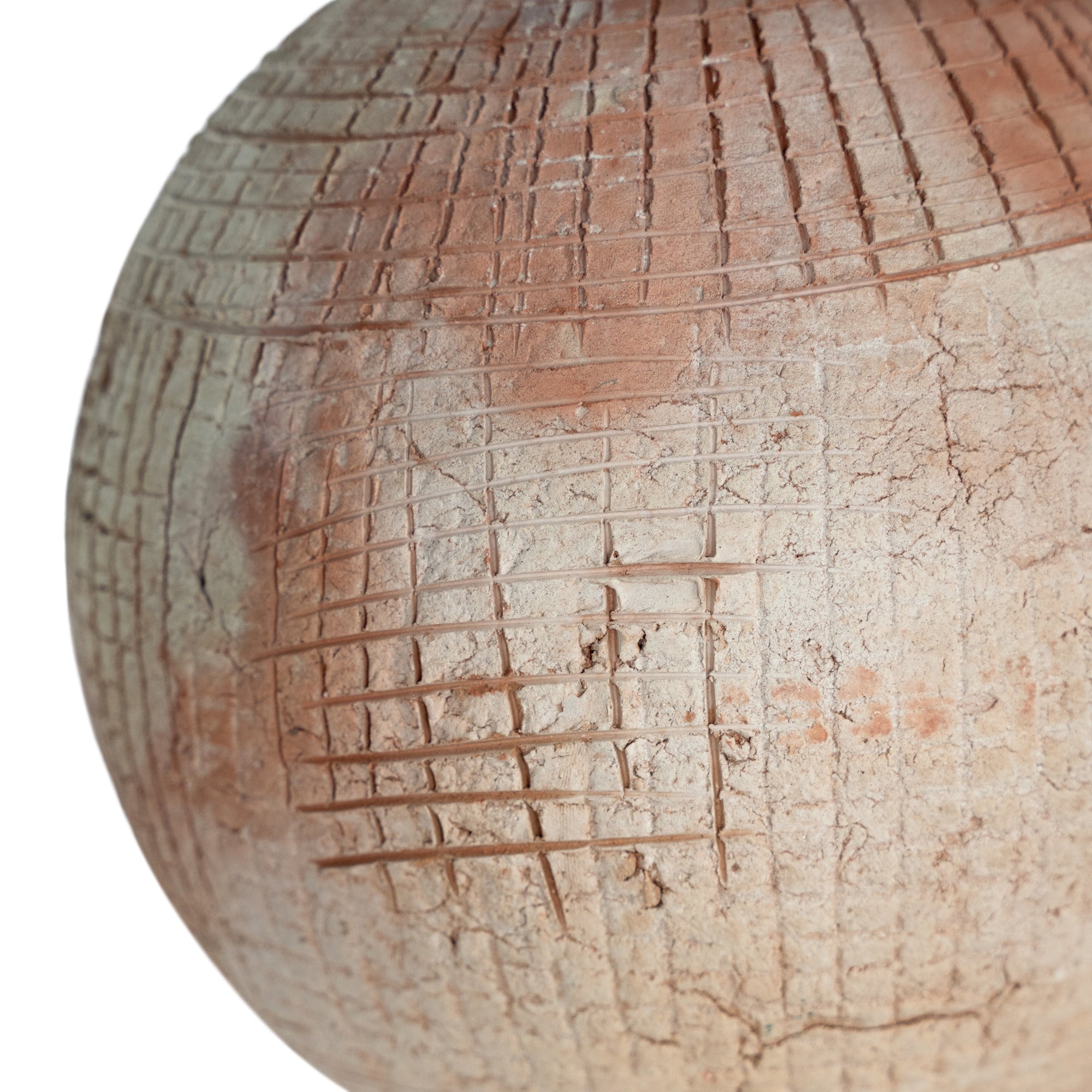 Terracotta table lamp featuring a textured spherical base with intricate grid detailing and a wide conical fabric shade in a neutral tone