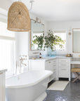 Luxury bathroom with a woven pendant light, freestanding bathtub, and elegant neutral decor creating a serene, spa-like retreat