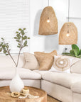 Relaxed living space featuring woven pendant lights, a natural linen sofa, and a wooden coffee table styled with organic décor elements