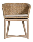 KULALA Living handwoven rattan dining chair with a curved backrest, natural wood legs, and a neutral seat cushion, blending coastal and contemporary design