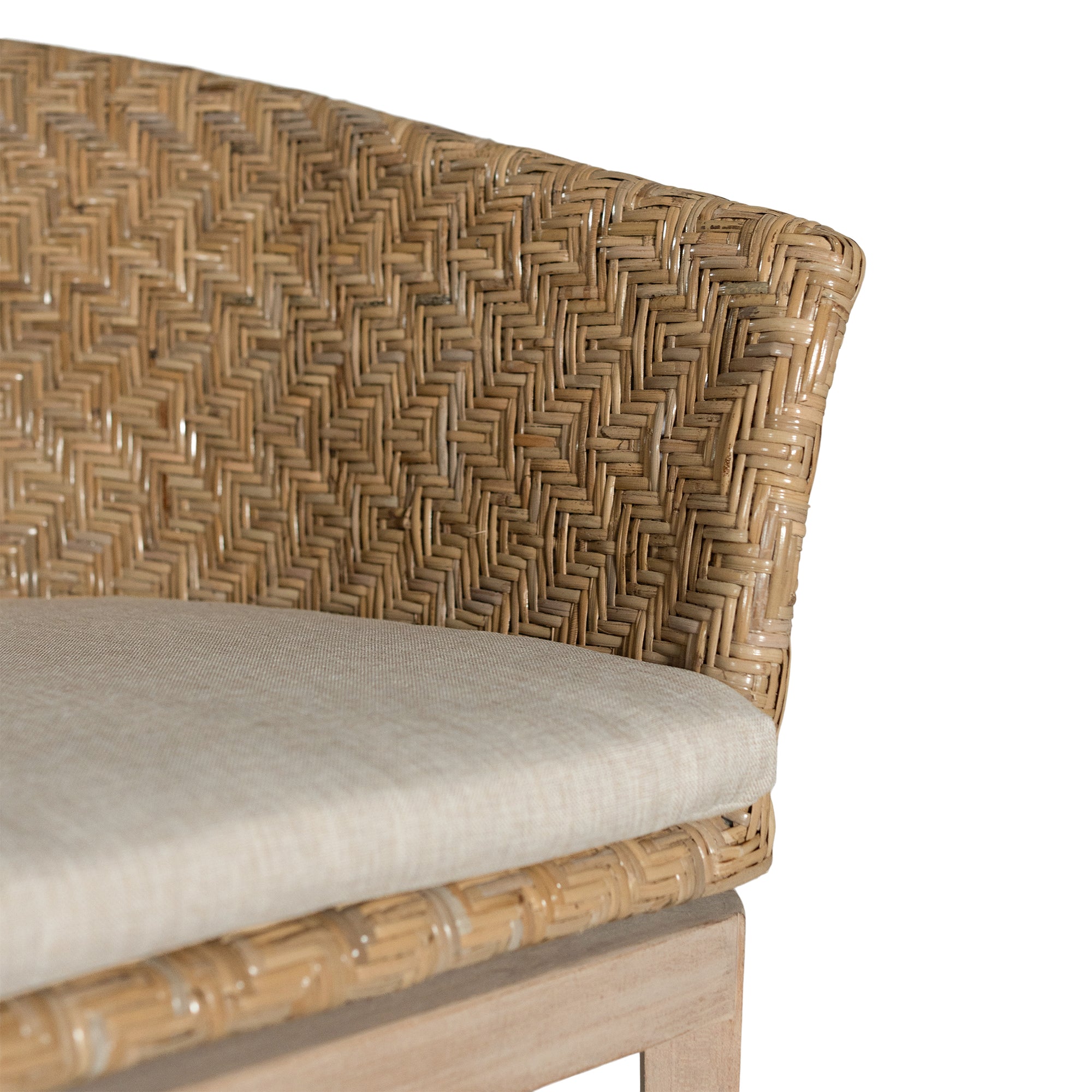 KULALA Living handwoven rattan dining chair with a curved backrest, natural wood legs, and a neutral seat cushion, blending coastal and contemporary design